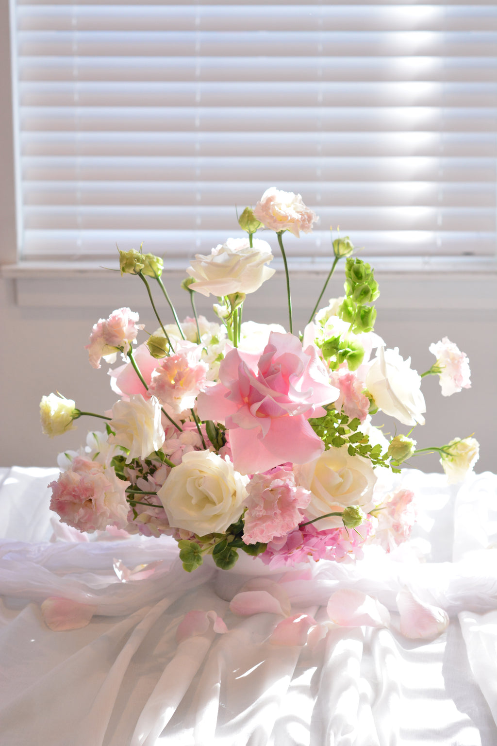 Garden-inspired wedding centerpieces with blush pink and white flowers on a romantic tablescape