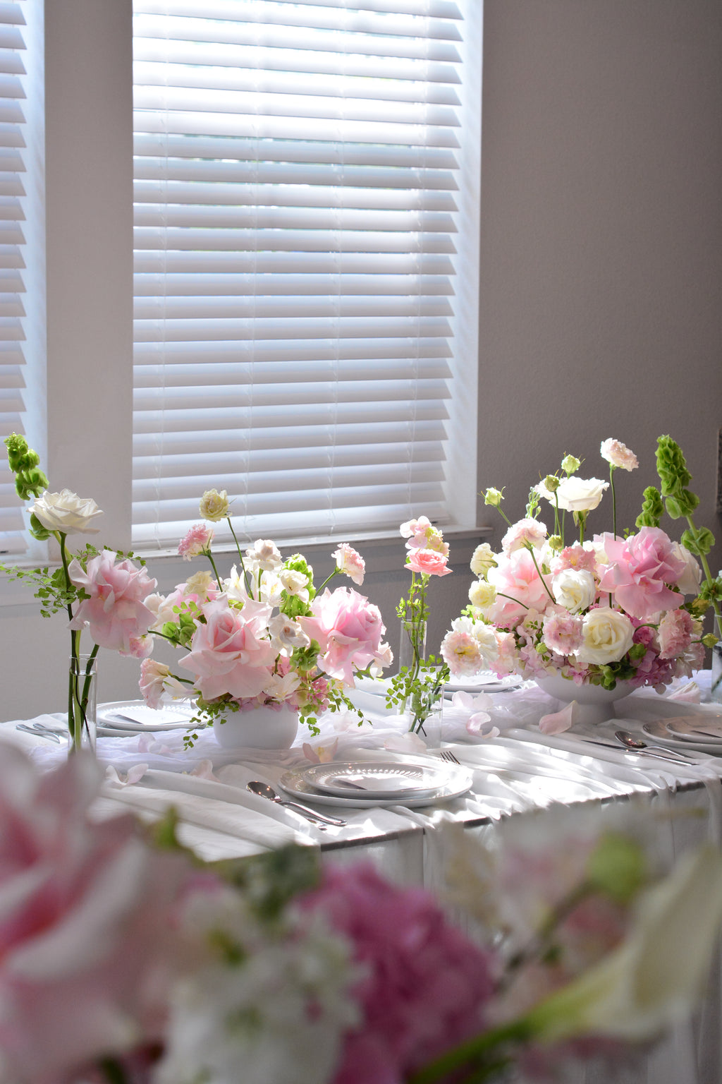 Garden-inspired wedding centerpieces with blush pink and white flowers on a romantic tablescape