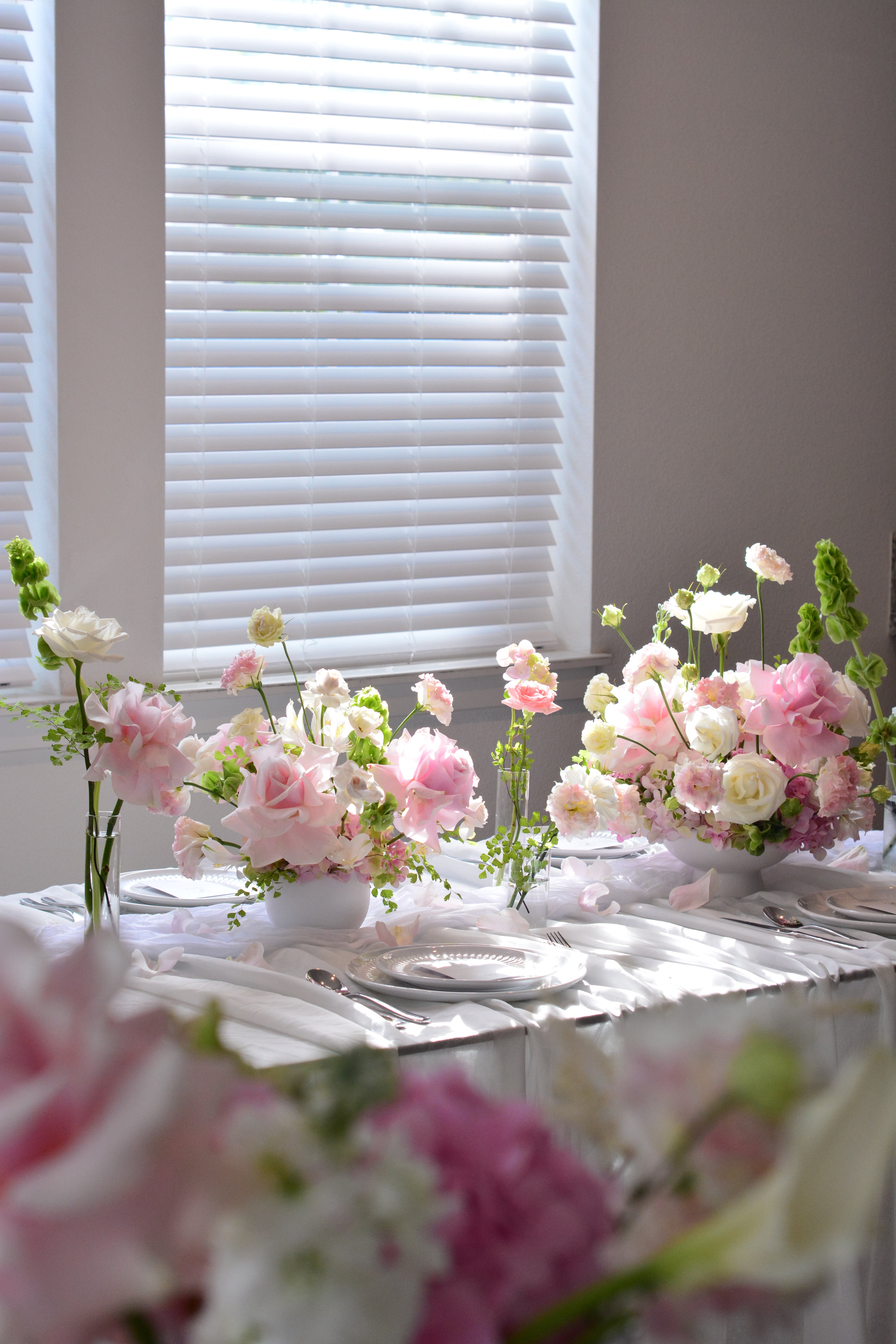 Garden-inspired wedding centerpieces with blush pink and white flowers on a romantic tablescape