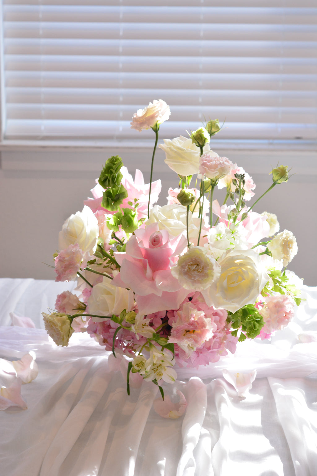 Garden-inspired wedding centerpieces with blush pink and white flowers on a romantic tablescape