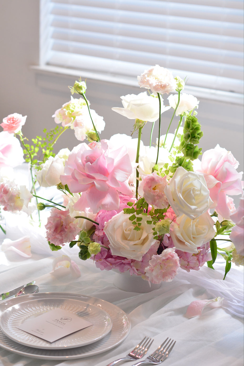 Garden-inspired wedding centerpieces with blush pink and white flowers on a romantic tablescape