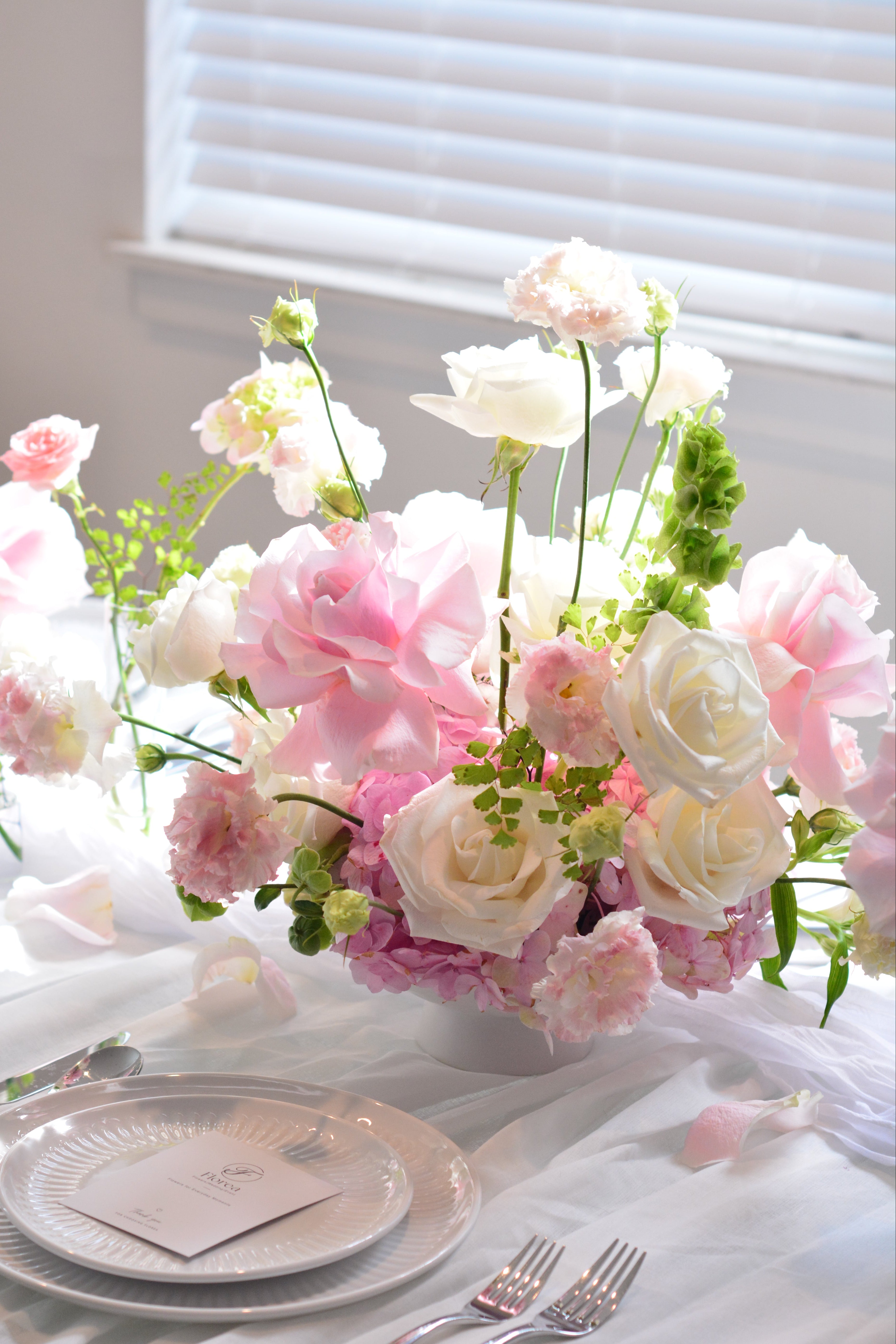 Garden-inspired wedding centerpieces with blush pink and white flowers on a romantic tablescape