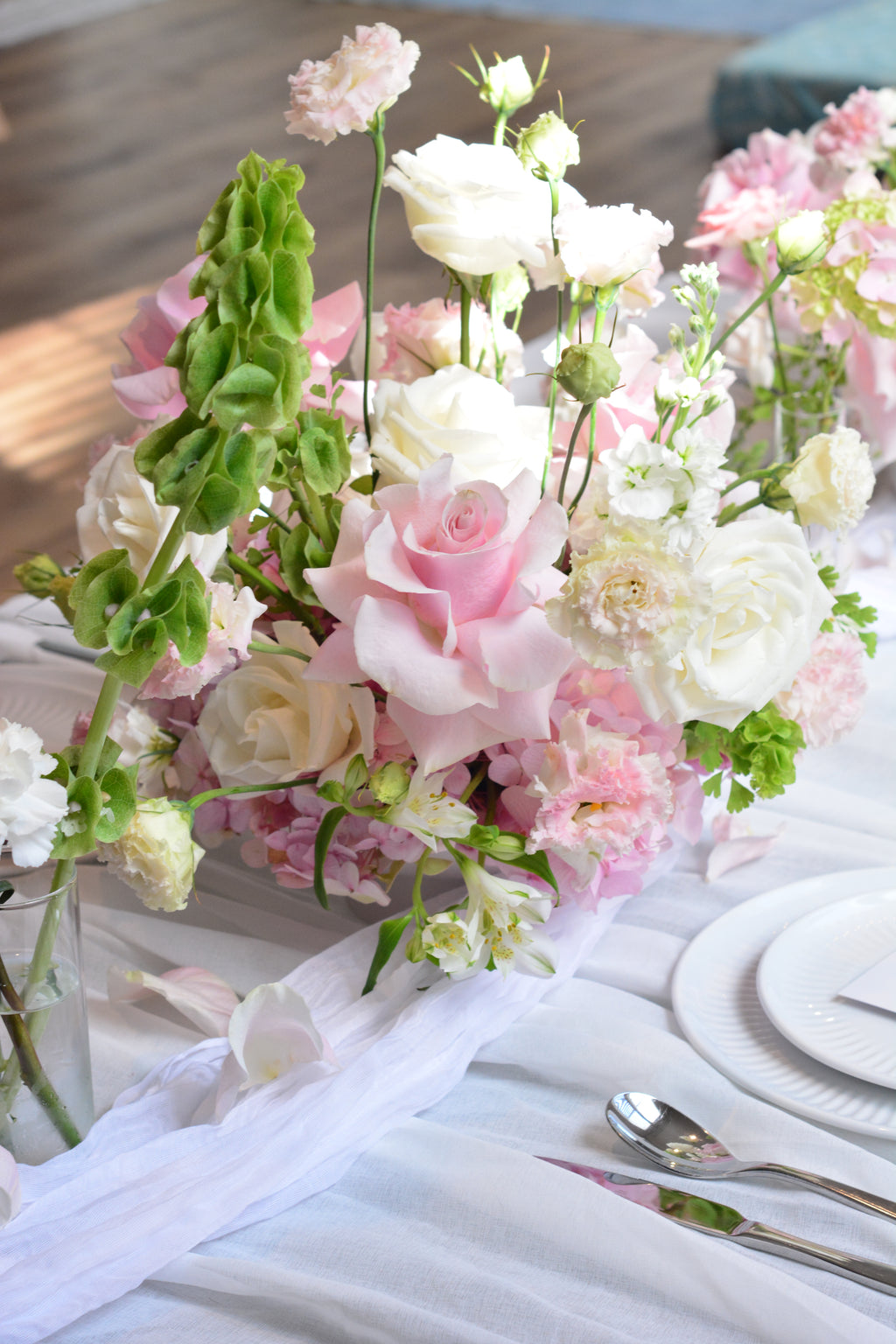 Garden-inspired wedding centerpieces with blush pink and white flowers on a romantic tablescape