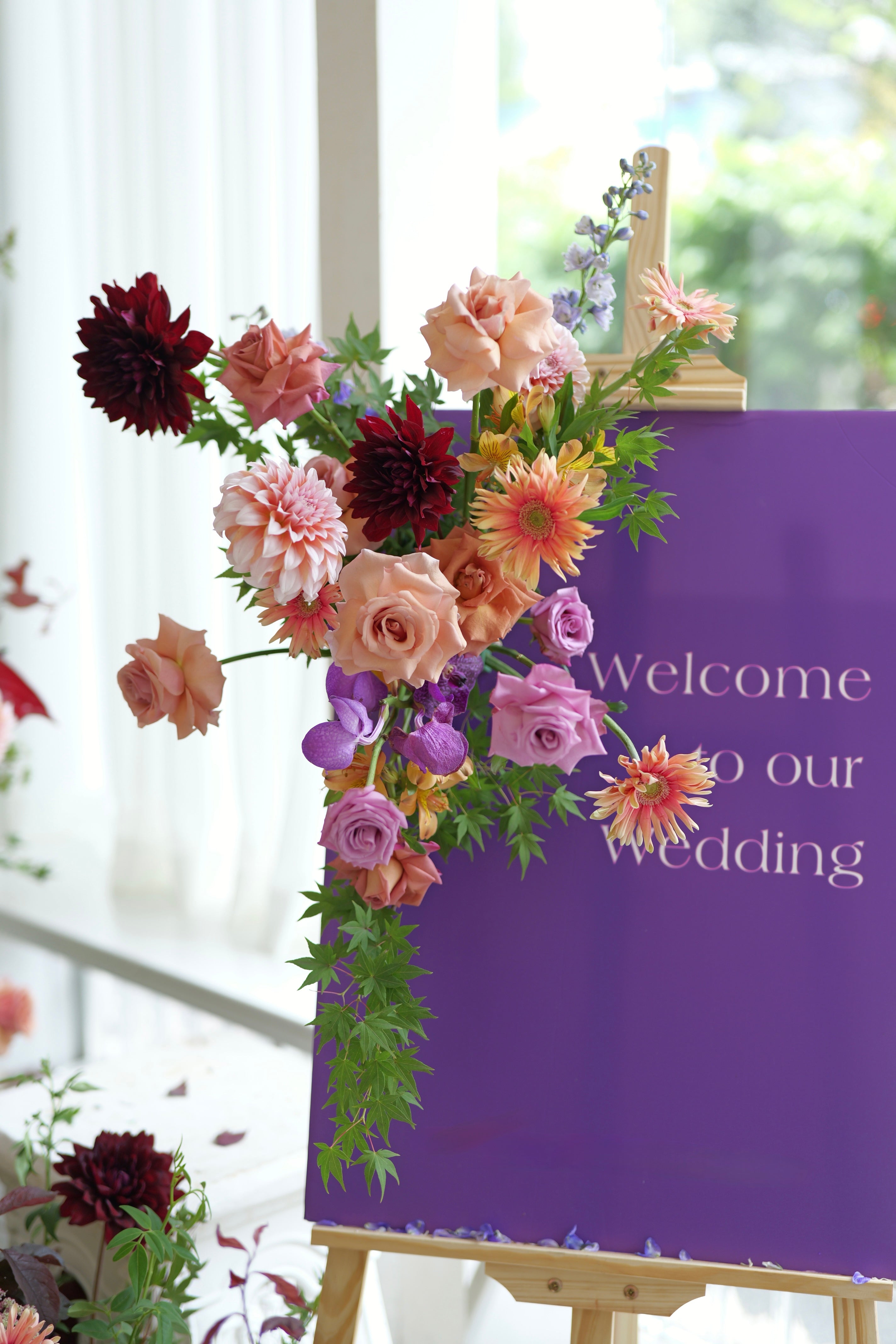 Floral arrangement on a purple Welcome sign with a blurred background