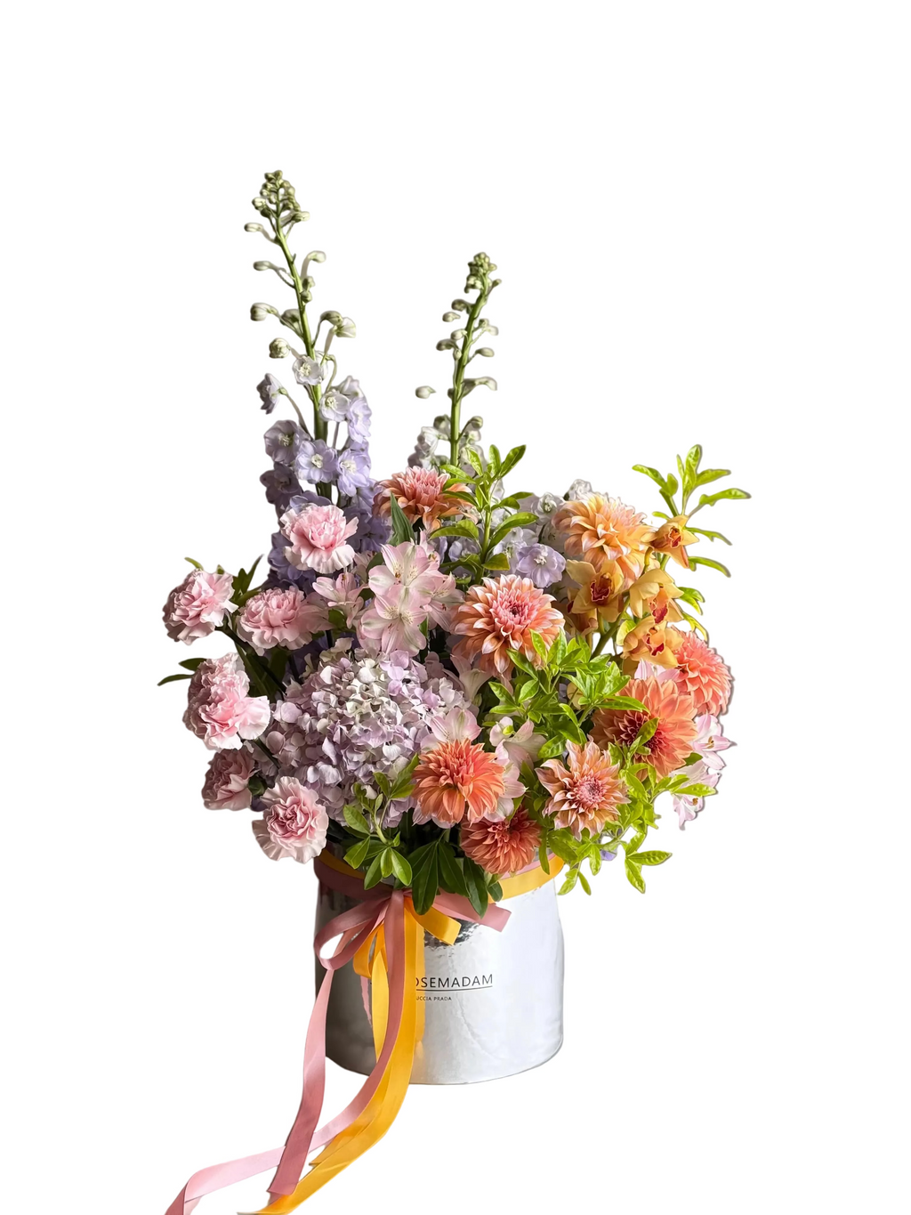 Bouquet of flowers in a silver box with a pink ribbon on a textured surface.