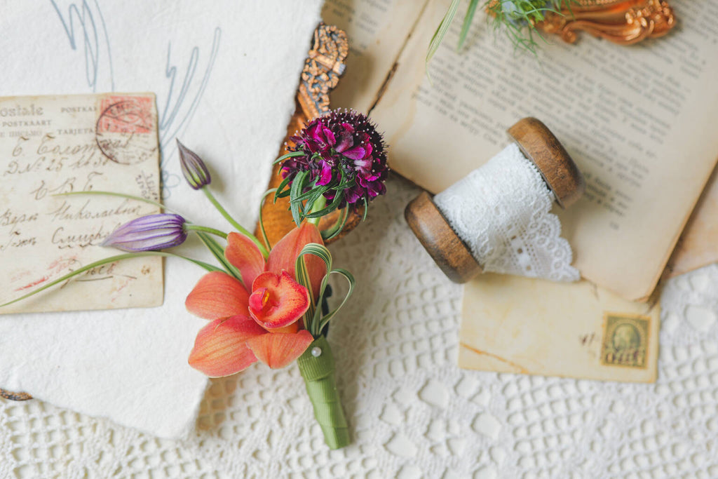 Orchid wedding boutonniere with purple floral accents