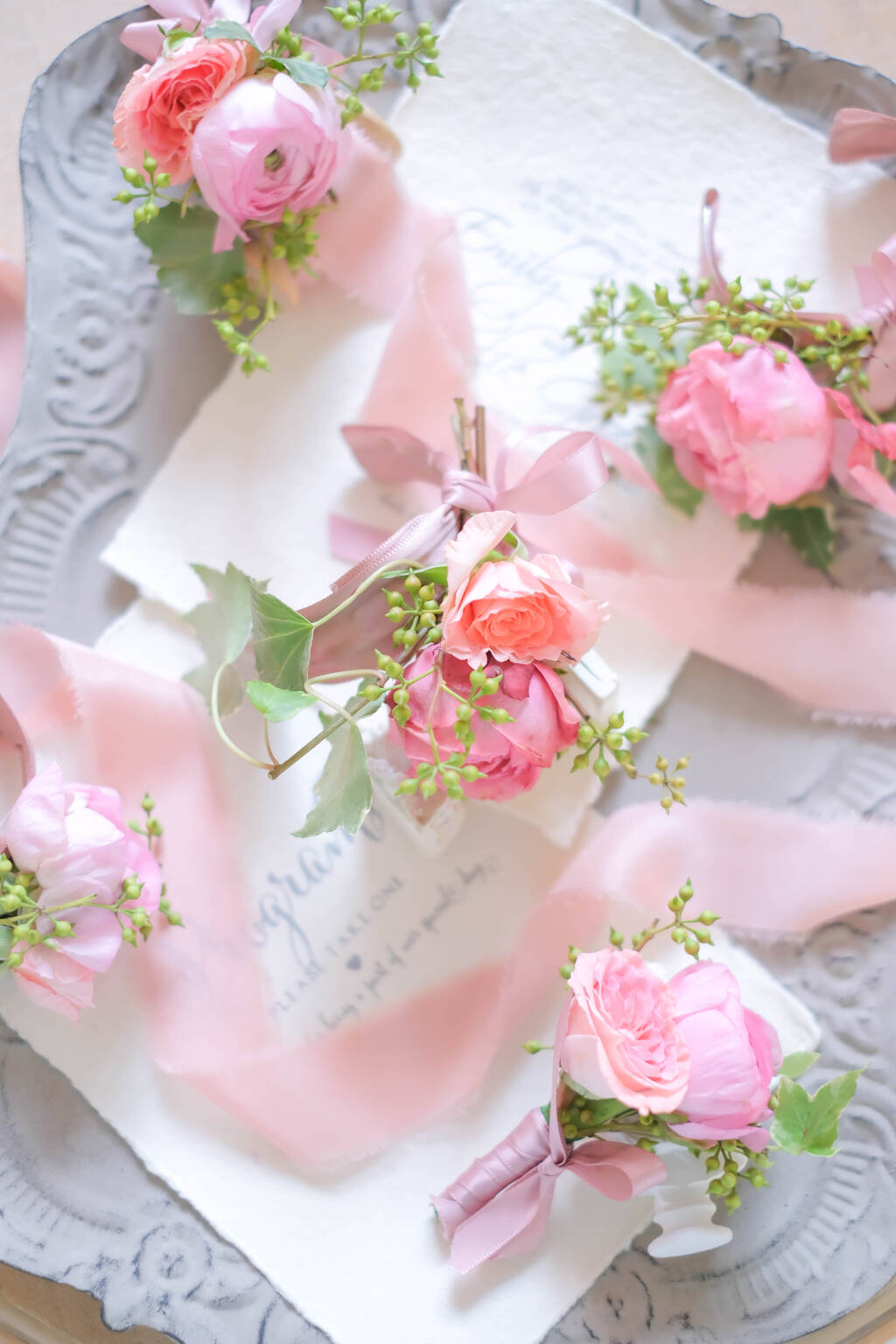 Custom pink garden rose and pink ranunculus boutonniere