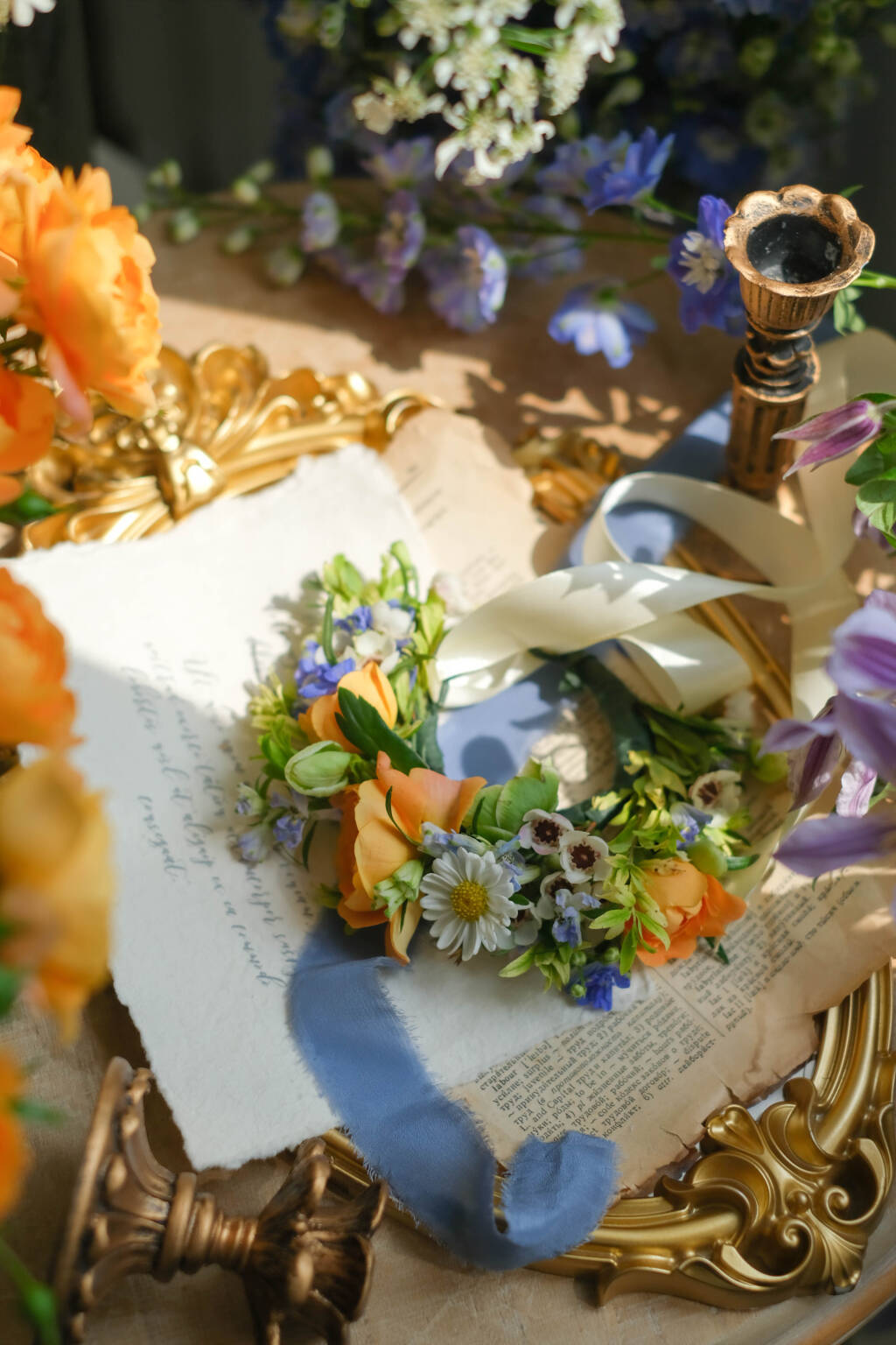 Whimsical floral crown with peach roses, daisies, and blue delphinium for weddings, festivals, and photoshoots