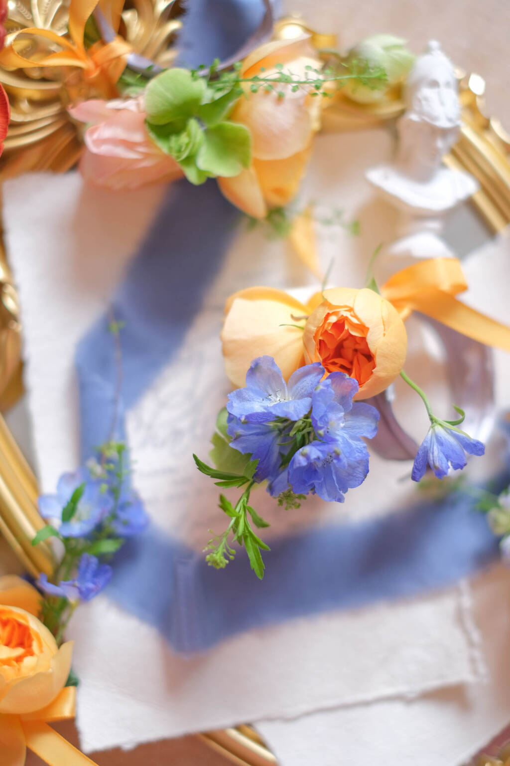 Orange rose wedding boutonniere with blue accents