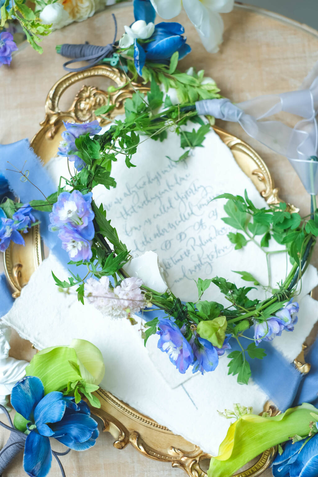 Blue and lavender floral crown with delphinium, calla lilies, and fresh greenery for weddings and special events