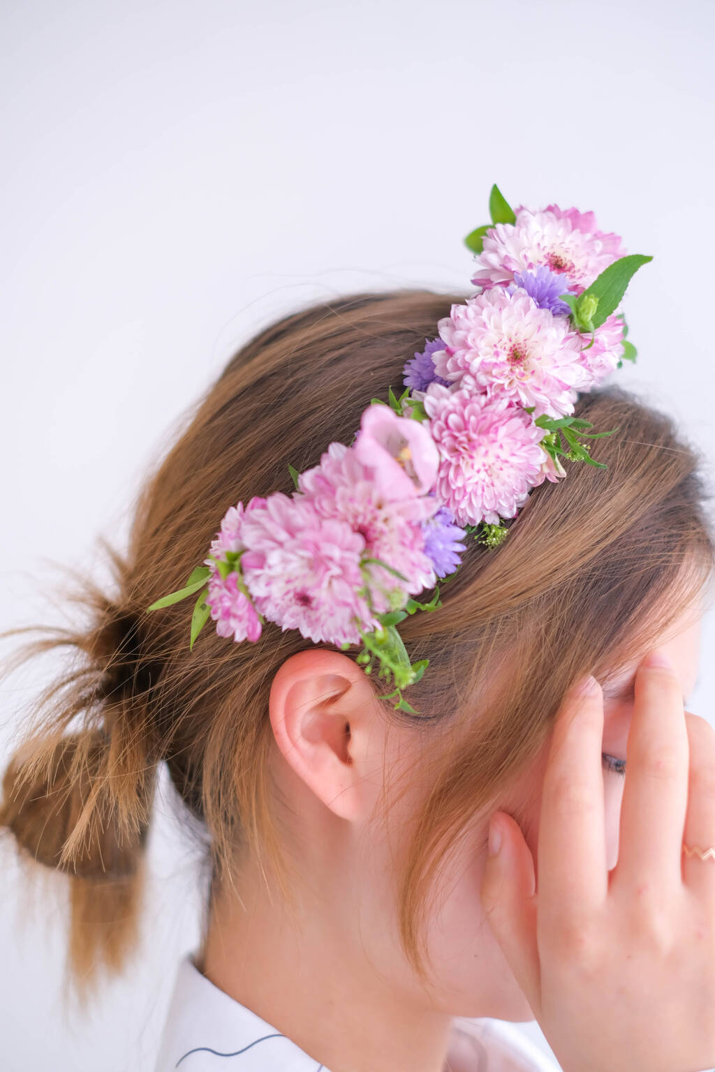 Pink floral crown featuring chrysanthemums and seasonal blooms worn as a romantic bridal hair accessory